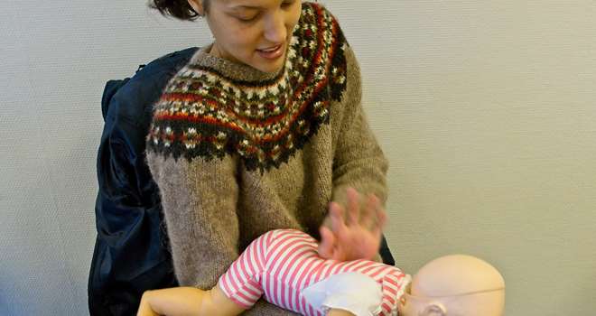 Førstehjælp baby mor holder dukke i arm galt i halsen.jpg
