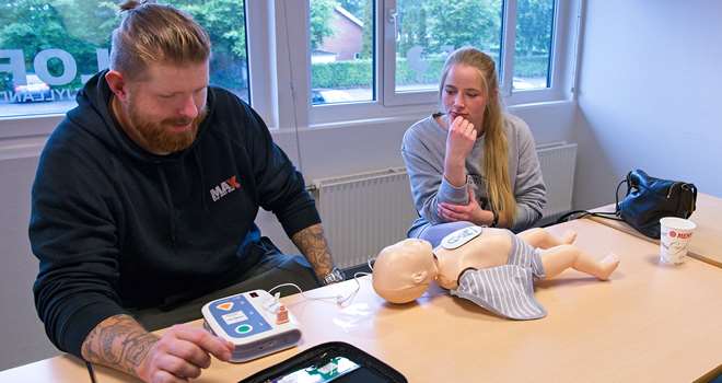 Førstehjælp baby par øver hjertestarter.jpg